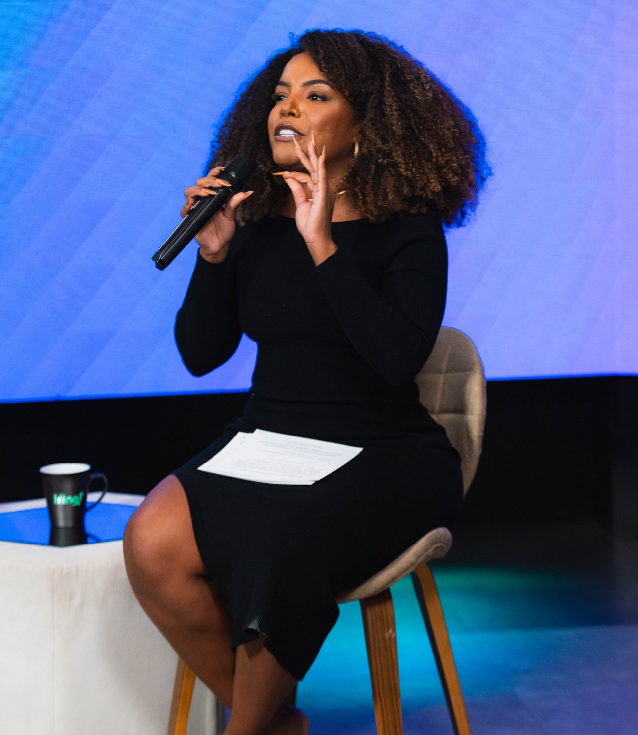 Amanda Santos palestrando com um microfone na mão